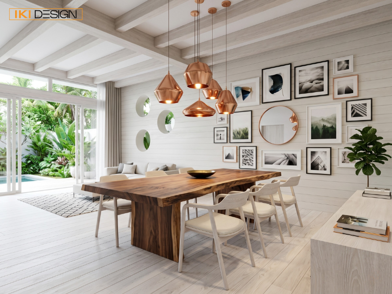 Sofa linen xám ở tiền cảnh dẫn lối đến bàn ăn gỗ và gallery wall nghệ thuật trong không gian mở thoáng đãng
